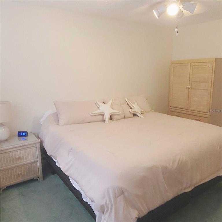 9344 Links Lane, Unit 9344 New Port Richey, FL 34655 - Photo 13 of 40 a bedroom with a bed and a night stand