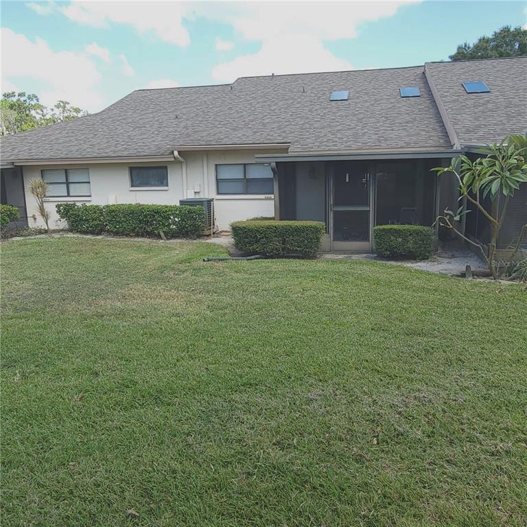 9344 Links Lane, Unit 9344 New Port Richey, FL 34655 - Photo 16 of 40 a front view of a house with a garden
