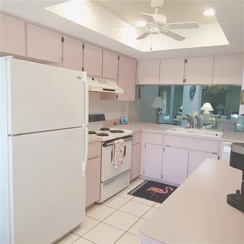 a kitchen with white cabinets and white appliances