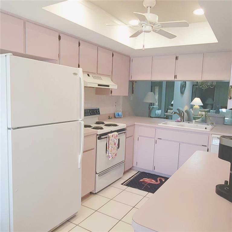 9344 Links Lane, Unit 9344 New Port Richey, FL 34655 - Photo 3 of 40 a kitchen with white cabinets and white appliances