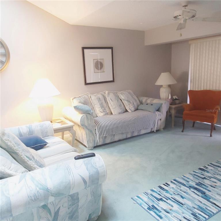 9344 Links Lane, Unit 9344 New Port Richey, FL 34655 - Photo 7 of 40 a living room with furniture and a lamp