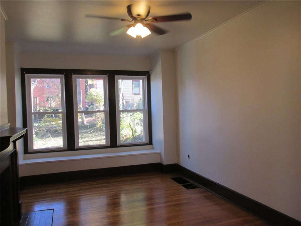 607 Gettysburg Street Pittsburgh, PA 15206 - Photo 5 of 13 a view of an empty room with wooden floor and a window