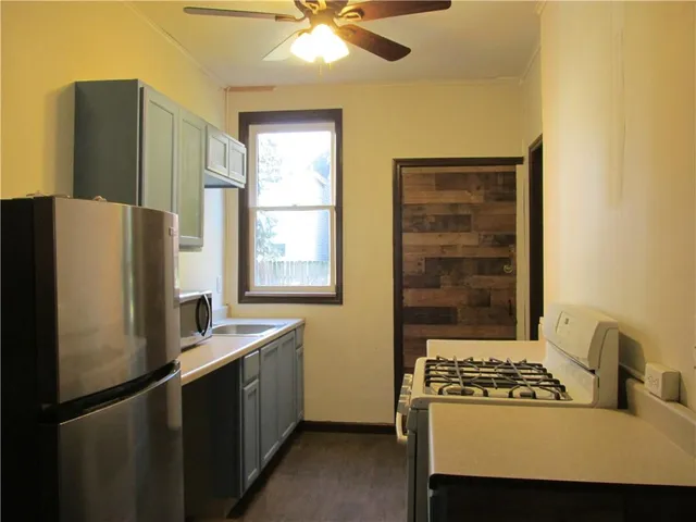a kitchen with a refrigerator a stove a sink and a window