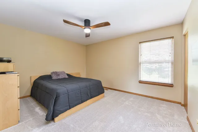 a living room with a bed furniture and a ceiling fan