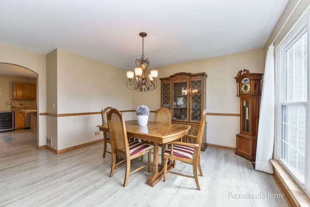a dining room with furniture a chandelier and wooden floor