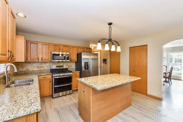 a kitchen with stainless steel appliances granite countertop a sink stove and refrigerator