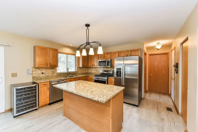 a kitchen with stainless steel appliances granite countertop a sink and a refrigerator