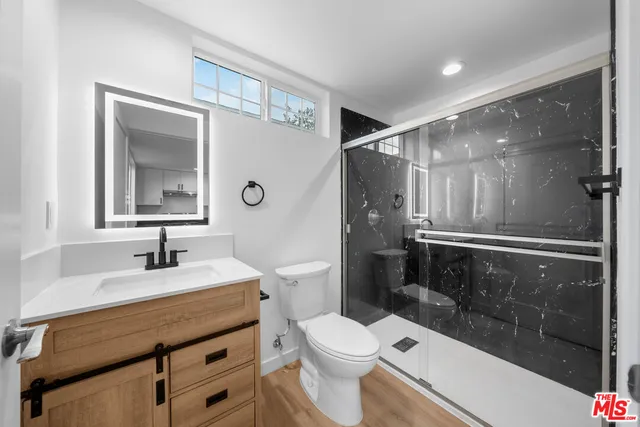 a bathroom with a sink a toilet and shower