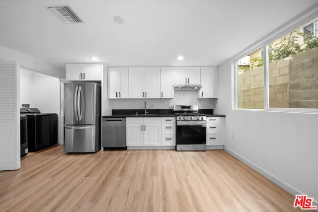 a kitchen with a refrigerator and a stove top oven