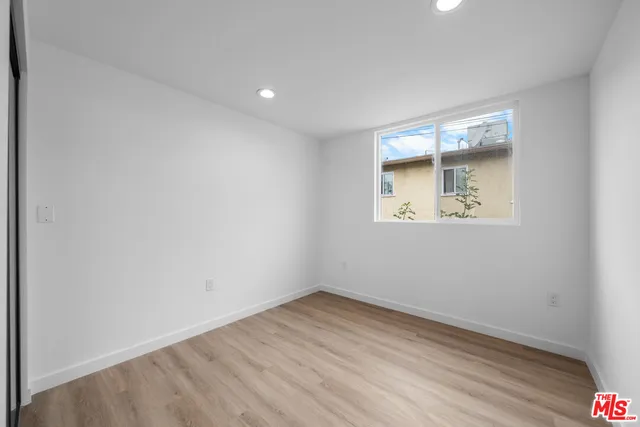 an empty room with wooden floor and a window