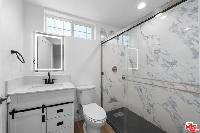 a bathroom with a sink toilet vanity and shower