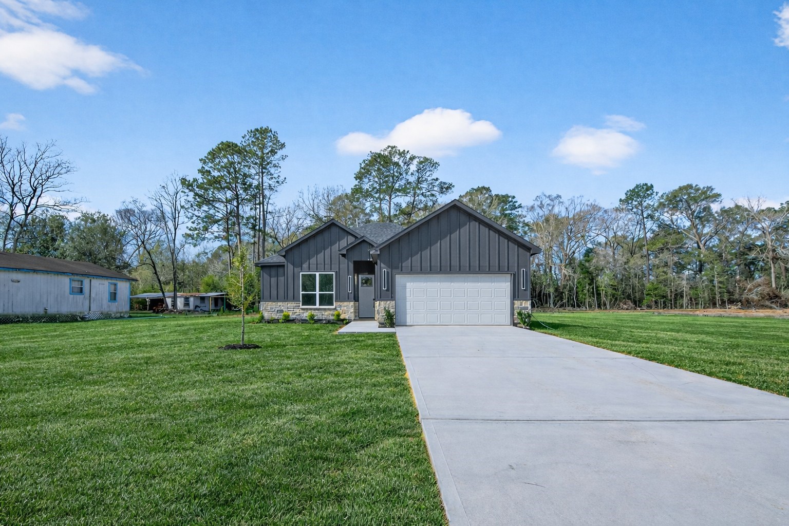 265 County Road 3376 Cleveland, TX 77327 - Photo 2 of 38 a front view of a house with a yard and garage