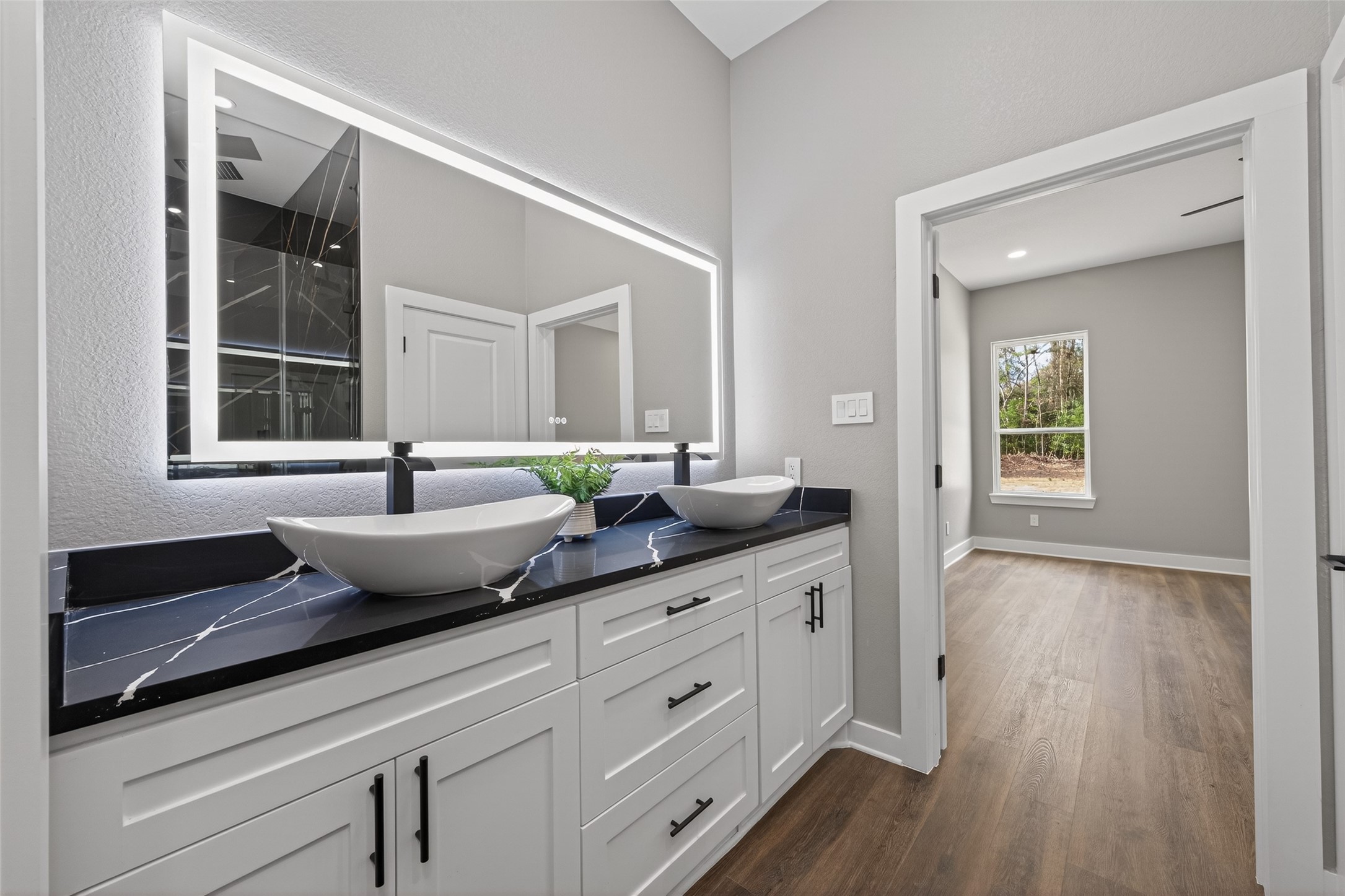 265 County Road 3376 Cleveland, TX 77327 - Photo 22 of 38 a spacious bathroom with a granite countertop sink and a large mirror