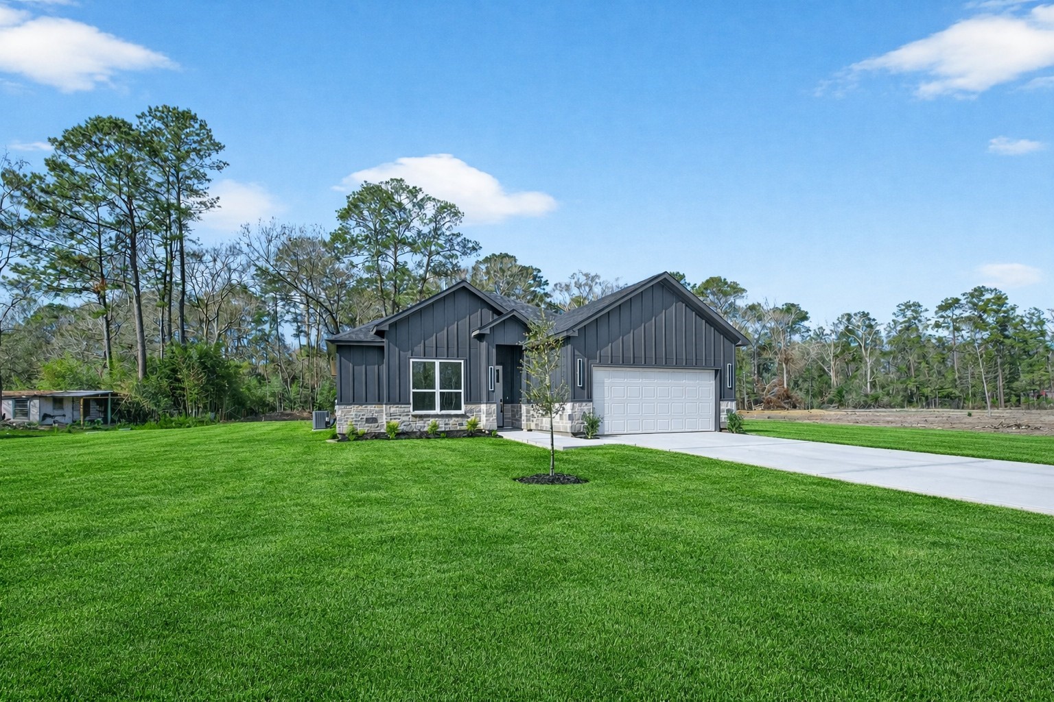 265 County Road 3376 Cleveland, TX 77327 - Photo 3 of 38 a front view of a house with a yard and trees