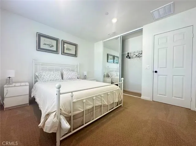 a spacious bedroom with a bed and a painting on the wall