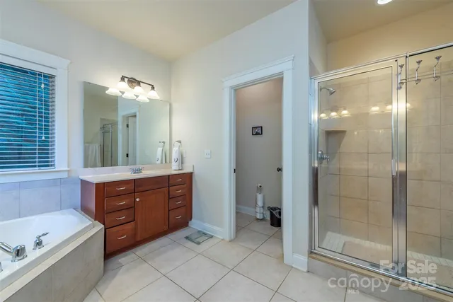 a bathroom with a tub sink shower and mirror