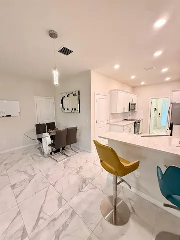 a living room with furniture and kitchen view