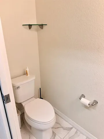 a white toilet sitting next to a white tub