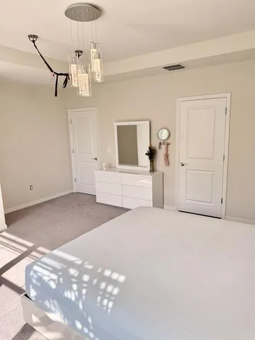 a view of a bedroom with a furniture and chandelier fan