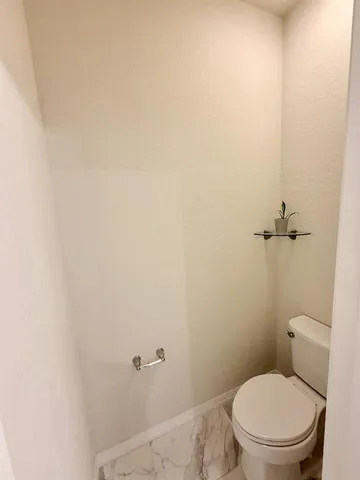 a bathroom with a granite countertop sink a toilet and shower