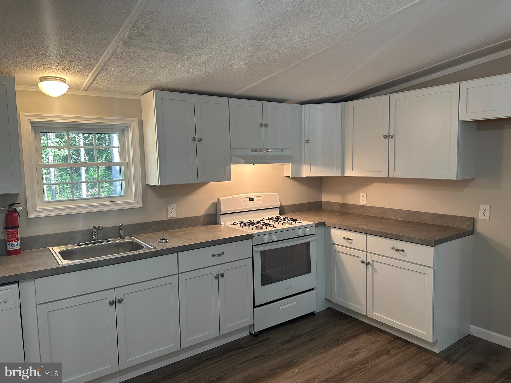 211 Maple Street Port Norris, NJ 08349 - Photo 7 of 28 a kitchen with granite countertop white cabinets and white appliances