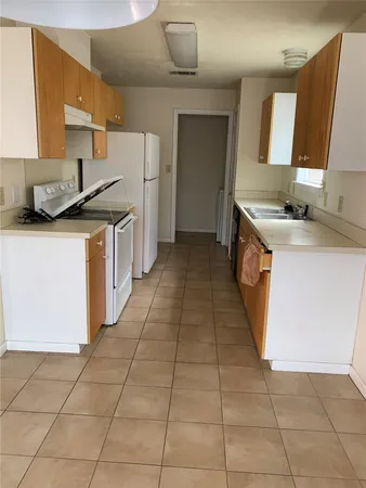 a kitchen with a sink a stove and a refrigerator