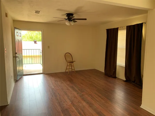 a view of a livingroom with wooden floor and a window