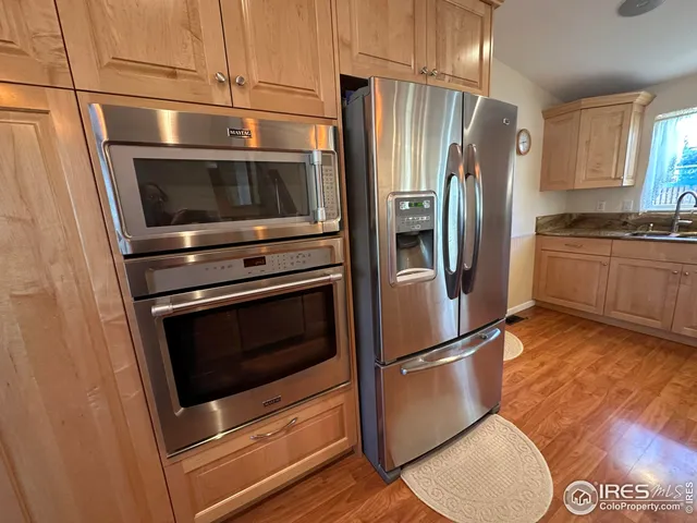 a kitchen that has a lot of cabinets in it and wooden floor