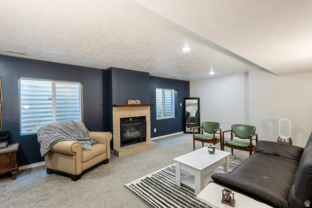 11751 Lake Run Road South Jordan, UT 84009 - Photo 24 of 38 Living area featuring a tiled fireplace with a wood mantle, recessed lighting, and carpet flooring