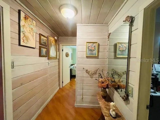 a backyard of a house with table and chairs under an umbrella