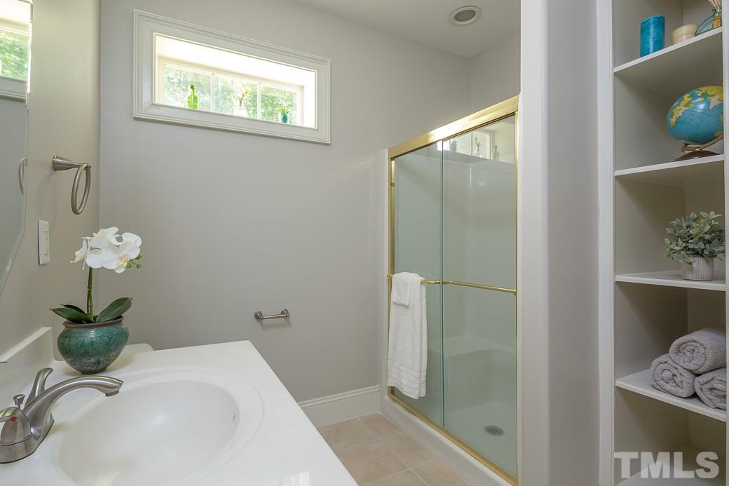 4901 Grilse Way Raleigh, NC 27613 - Photo 13 of 19 Private bath for one of the secondary bedrooms with new paint, built-in shelves and lots of natural light.