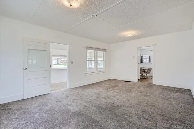 an empty room with windows and closet