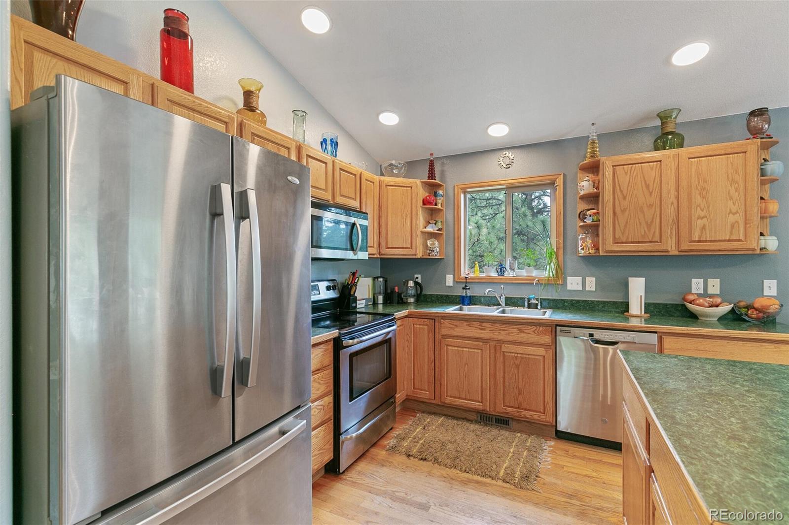 30 Bristlecone Circle Bailey, CO 80421 - Photo 13 of 35 a kitchen with stainless steel appliances granite countertop a refrigerator a sink dishwasher a stove with wooden cabinets and floor