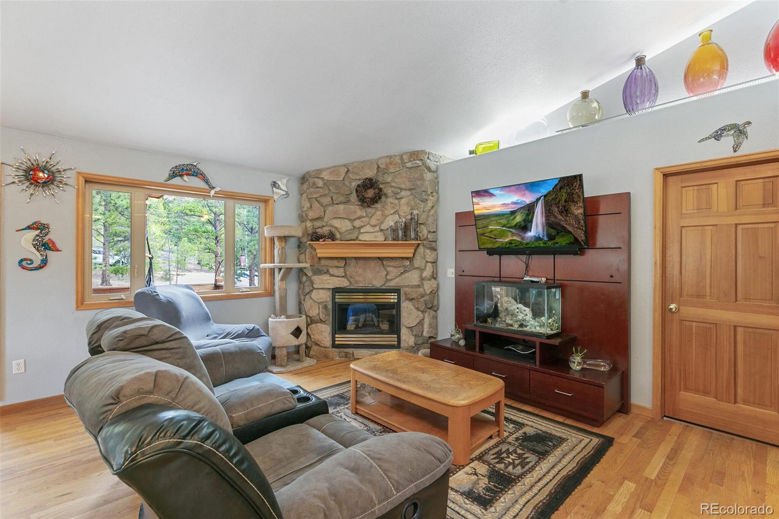 30 Bristlecone Circle Bailey, CO 80421 - Photo 5 of 35 a living room with furniture a flat screen tv and a fireplace