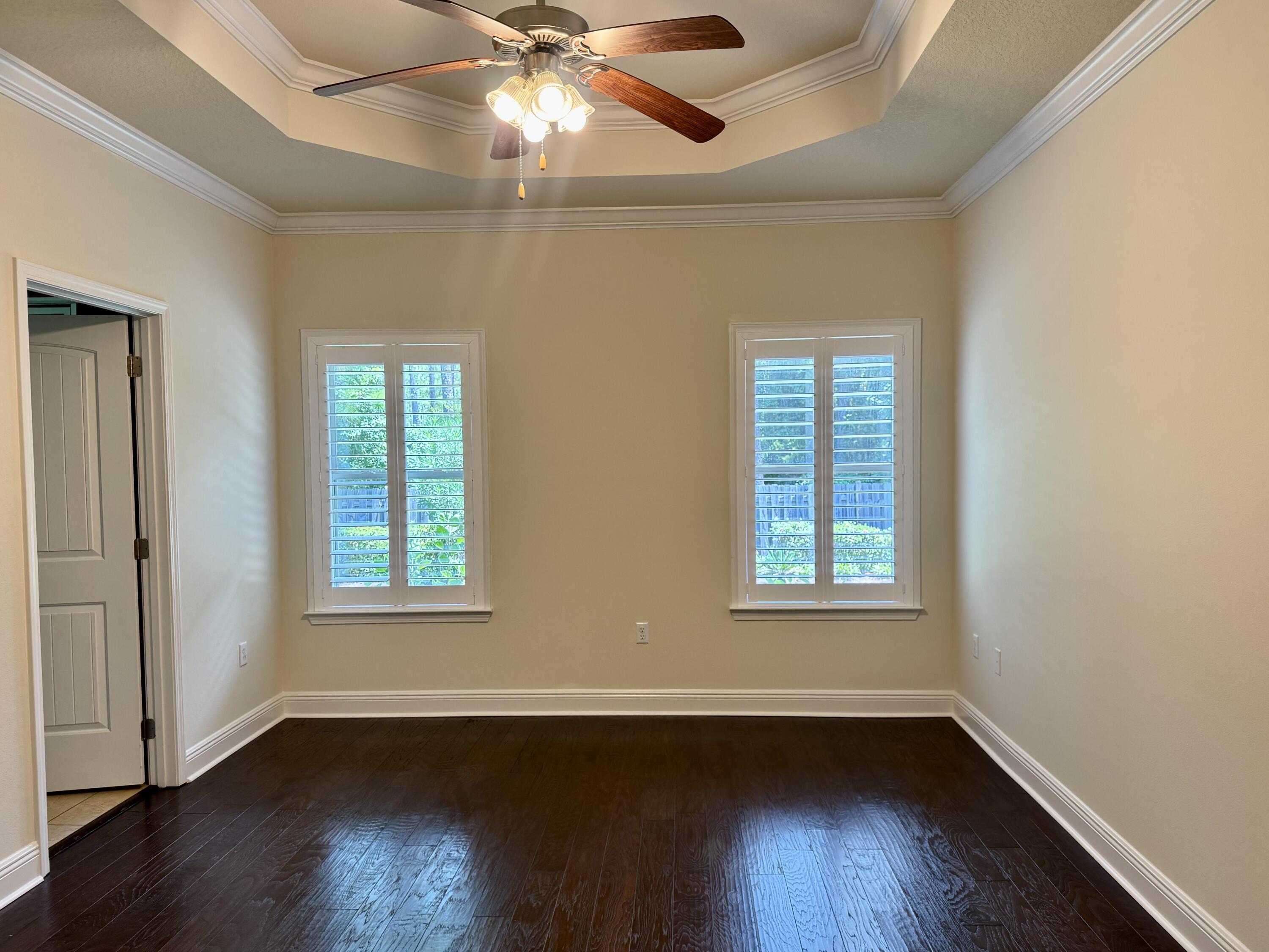 256 Cocobolo Drive Santa Rosa Beach, FL 32459 - Photo 16 of 22 an empty room with wooden floor chandelier fan and windows