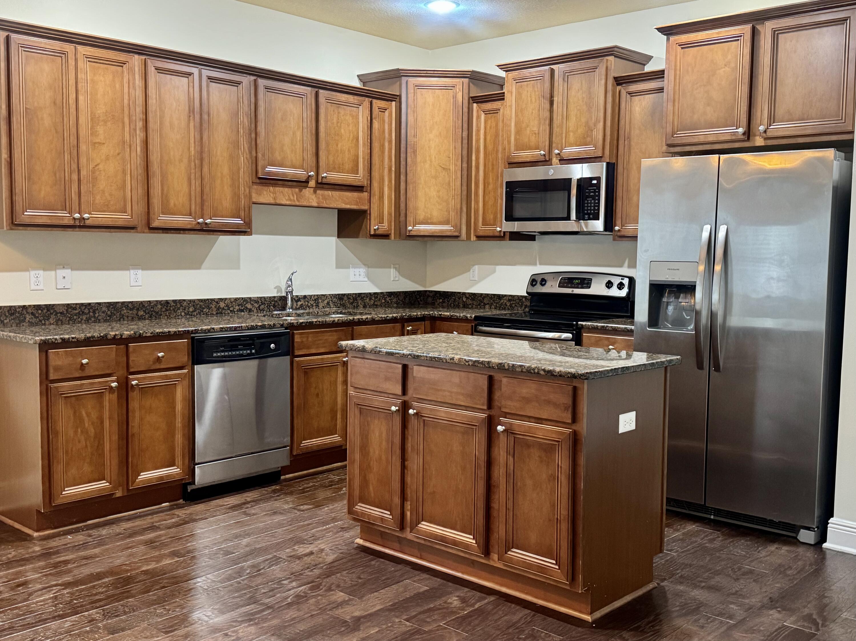 256 Cocobolo Drive Santa Rosa Beach, FL 32459 - Photo 7 of 22 a kitchen with stainless steel appliances granite countertop a stove a microwave and a refrigerator