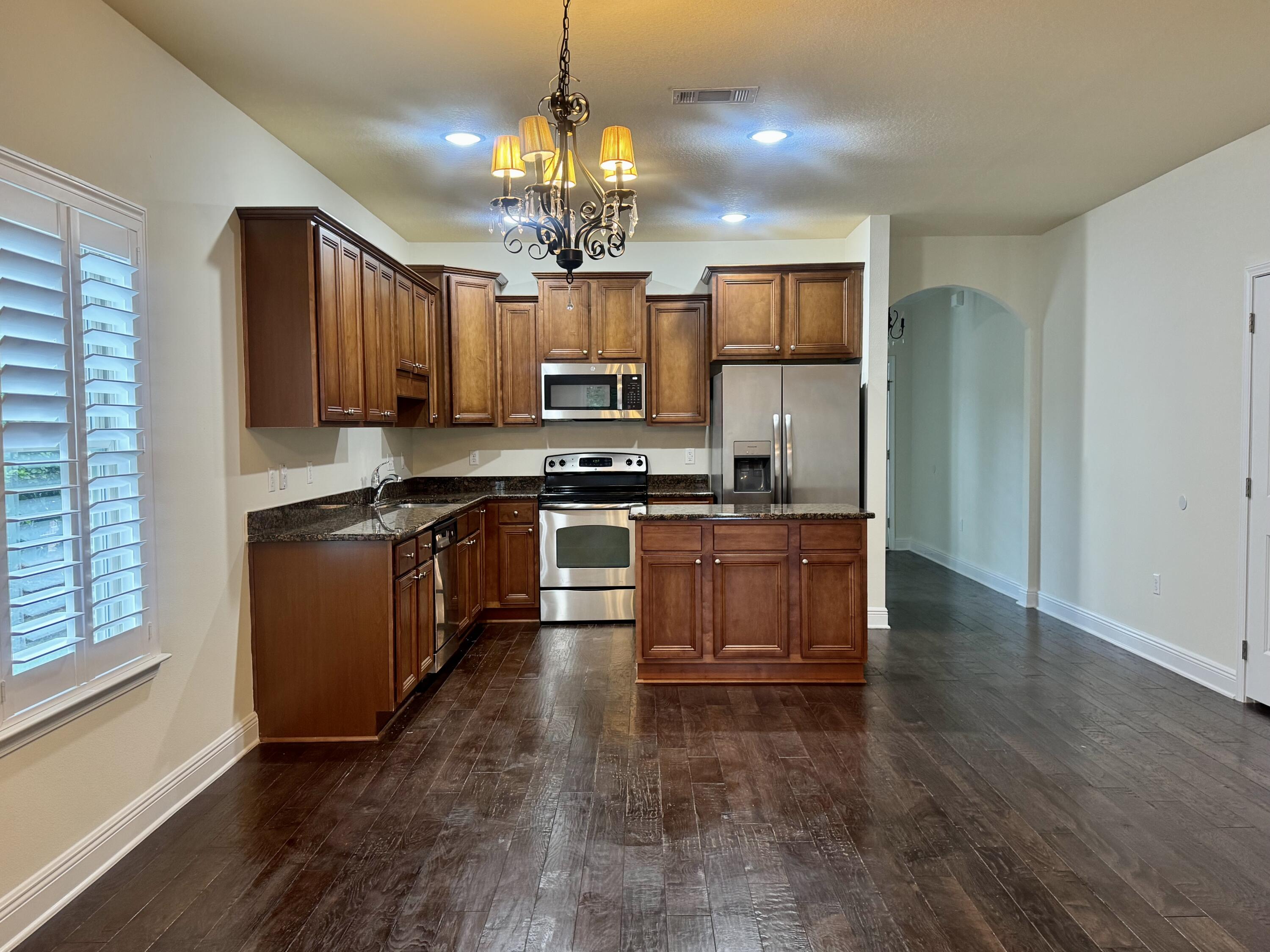 256 Cocobolo Drive Santa Rosa Beach, FL 32459 - Photo 8 of 22 a large kitchen with stainless steel appliances granite countertop a stove a sink dishwasher and a refrigerator with wooden floor