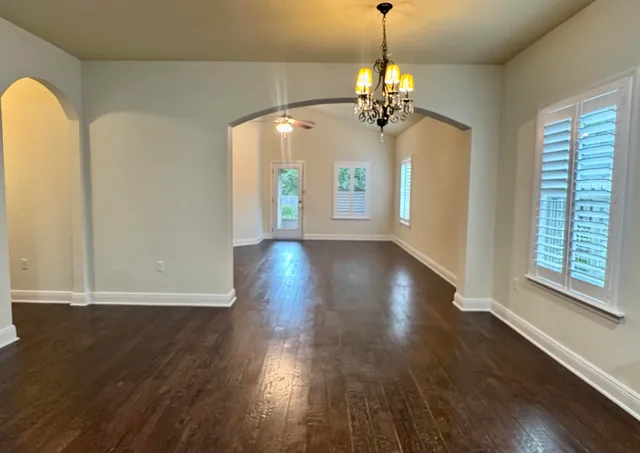 a view of a room with wooden floor and chandelier