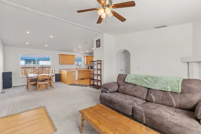 a living room with furniture and a dining table with kitchen view