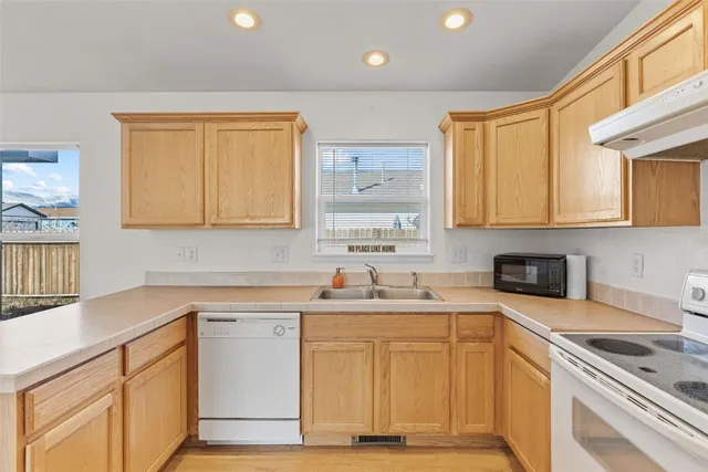 a kitchen with stainless steel appliances granite countertop a sink stove and cabinets