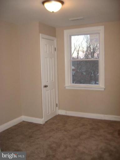 916 Andover Road Baltimore, MD 21218 - Photo 22 of 30 an empty room with wooden floor and windows