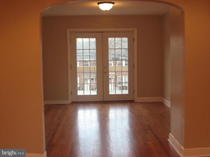 916 Andover Road Baltimore, MD 21218 - Photo 5 of 30 an empty room with wooden floor and windows