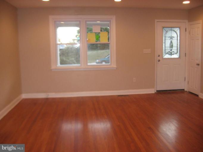 916 Andover Road Baltimore, MD 21218 - Photo 6 of 30 a view of an empty room with wooden floor and a window