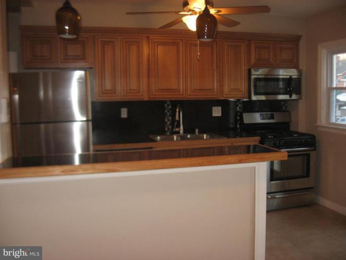 916 Andover Road Baltimore, MD 21218 - Photo 9 of 30 a kitchen with stainless steel appliances granite countertop a refrigerator and a stove top oven