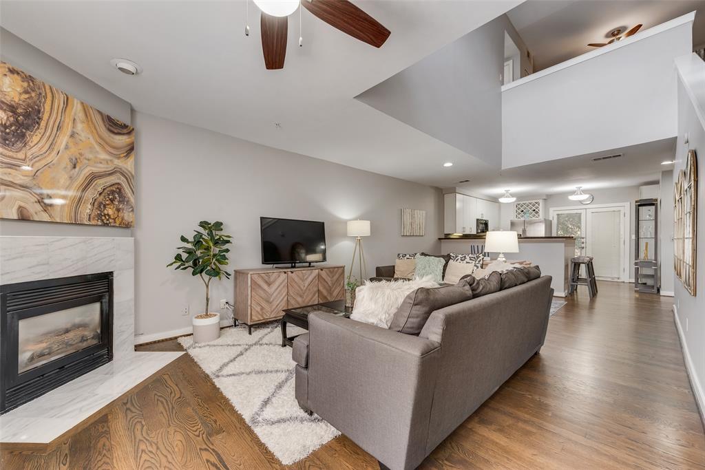 3922 Gilbert Avenue, Unit 220 Dallas, TX 75219 - Photo 2 of 19 a living room with furniture a fireplace and a flat screen tv