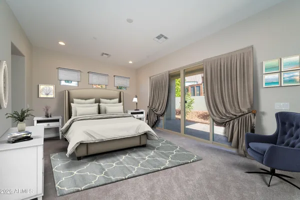 a spacious bedroom with a bed a couch and a window