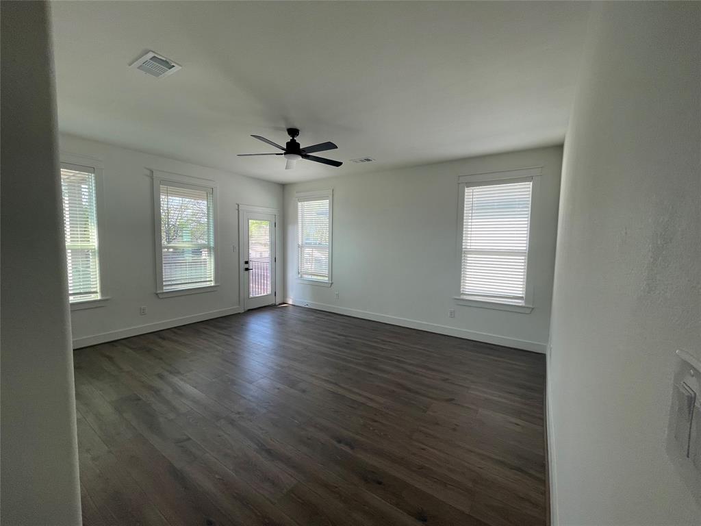 3535 Spring Avenue Dallas, TX 75210 - Photo 13 of 19 Empty room with ceiling fan and dark wood-style floors