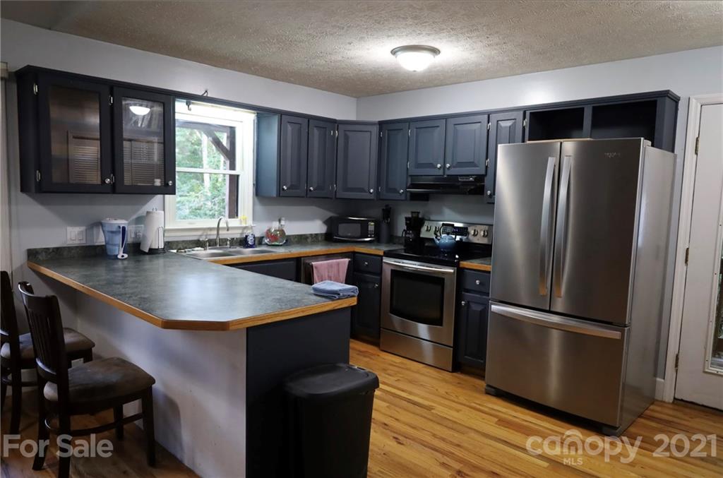 263 Cedar Rock Road Waynesville, NC 28786 - Photo 11 of 20 a kitchen with kitchen island a sink appliances and cabinets