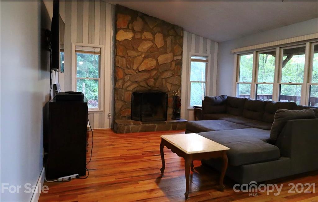263 Cedar Rock Road Waynesville, NC 28786 - Photo 6 of 20 a living room with furniture a large window and a fireplace