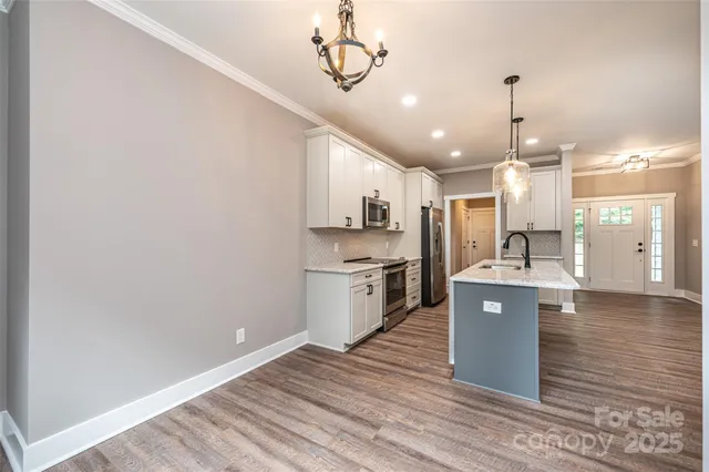 a kitchen with stainless steel appliances granite countertop a sink a stove and a refrigerator